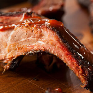 smoked BBQ ribs fresh off of the smoker grill with delicious sauce added.
