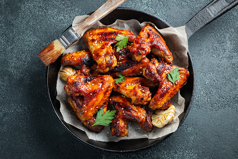 Smoked Chicken Wings Baked chicken wings in barbecue sauce with sesame seeds and parsley